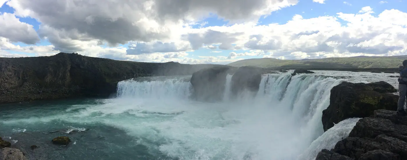 Tosender Wasserfall unter bewölktem Himmel