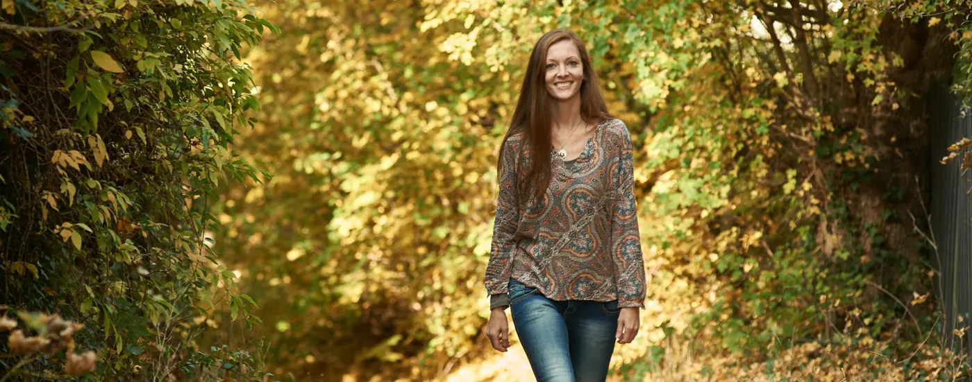 Judith Guserl auf einem herbstlichen Waldweg