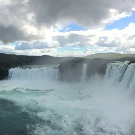 Tosender Wasserfall unter bewölktem Himmel